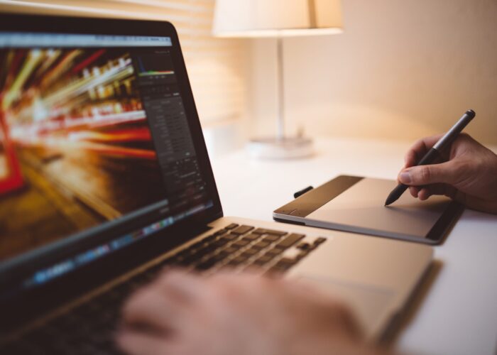 Canva - Person Using Laptop and Drawing Pad on Table